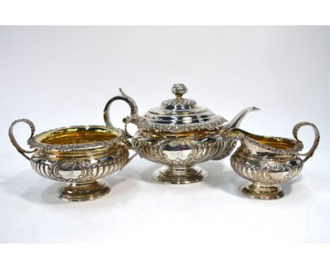 A George IV Regency-style Scottish silver three-piece tea service of compressed melon form, the teapot with cauliflower finia