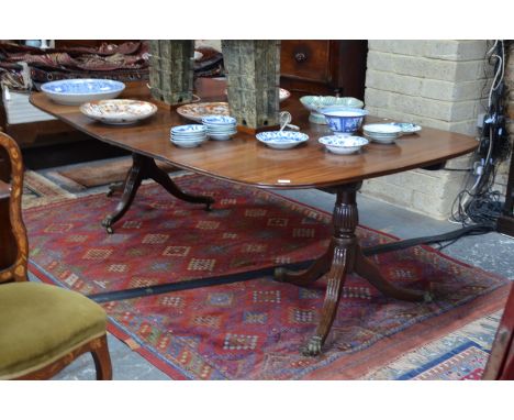 A mahogany twin pedestal dining table, each D-end raised on turned supports to moulded tripod legs on castors, to/w two wide 