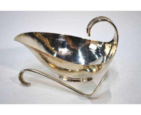 Robert Edgar Stone (1903-1990), a planished silver sauce boat with ladle, engraved with rose motif, London 1955 (ladle) and 1