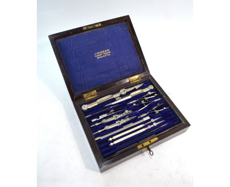 A vintage rosewood cased set of nickel and steel drawing instruments, two with turned bone handles, by J. Halden & Co., Manch