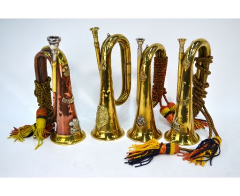 A copper and brass Welsh Regiment bugle, with applied badges, to/w three other brass bugles with military badges - Royal Warw