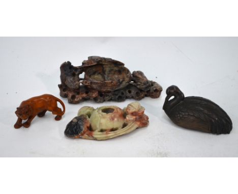 A Japanese metal scroll weight designed as a recumbent crane, 9 cm long; together with a wood netsuke of a tiger; and two pie