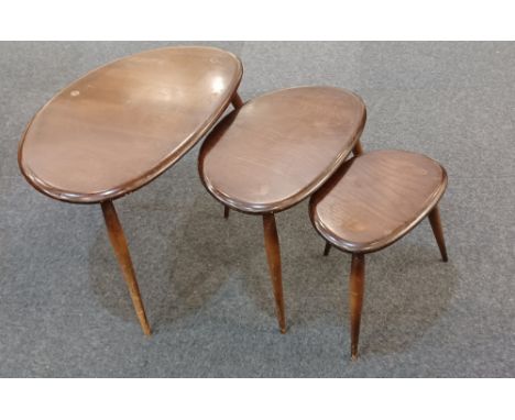 An Ercol nest of three 'pebble' occasional tables in dark wood, with original labels largest 64cm