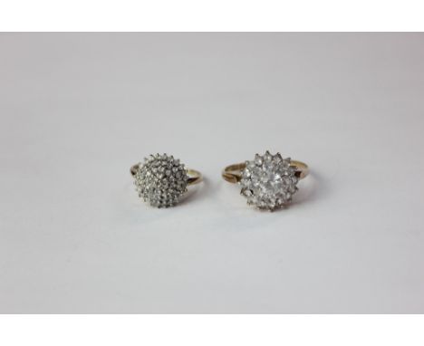 A diamond domed cluster ring the centre stone within a three row border in 9ct gold; and a three row domed cluster ring