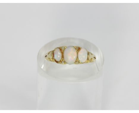 An 18ct gold opal and diamond ring set with three graduated oval cabochon opals all four grain set with four eight cut diamon