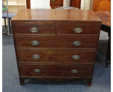 A George III mahogany chest of two short over three long drawers with brass drop handles and oval embossed back plates, on br
