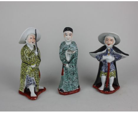 Three Japanese glazed pottery figures polychrome decorated 17cm high