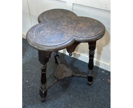 A 17th century style carved oak table with clover leaf shaped top and under shelf on turned legs 51cm