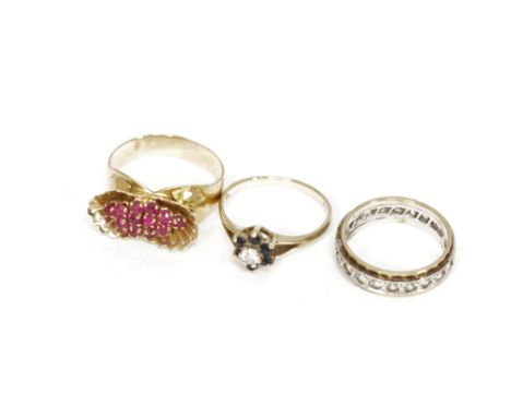 A sapphire and cubic zirconia cluster ring set in 9ct gold, and a ruby flower dress ring set in yellow metal, together with a