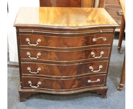 A reproduction mahogany serpentine front chest of drawers, with crossbanded top above brushing slide and four graduated drawe