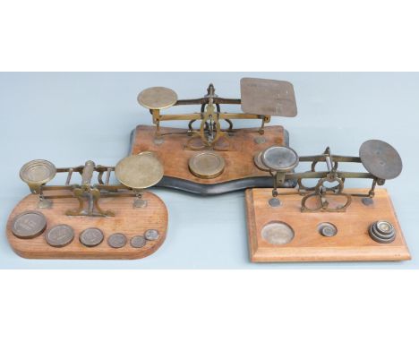 Three sets of Victorian brass postage scales, one with Avery weights, width of largest 25cm