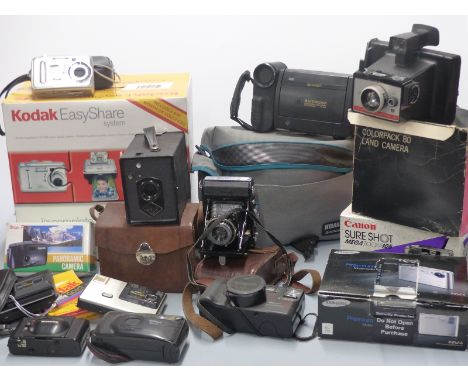 Quantity of cameras and accessories including Kodak EasyShare printer, Canon Sureshot Megazoom 105, Samsung NV4, Sharp 8 view