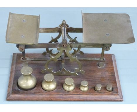 Victorian brass postage scales with rates to pan and bun-shaped weights to base from 8oz downwards, width 24cm