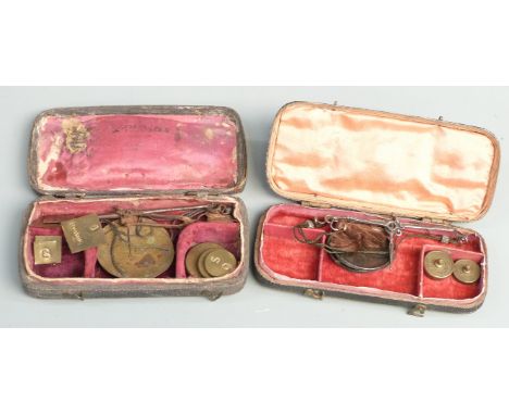 Two shagreen or similar cased travelling beam scales with weights. Width of larger case 11cm