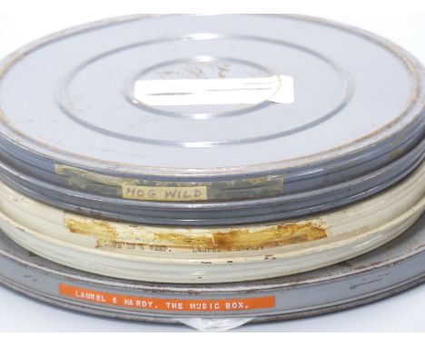 Three vintage Laurel &amp; Hardy 16mm cine film reels marked 'Love 'em &amp; Weep', 'Hog Wild' and 'The Music Box'