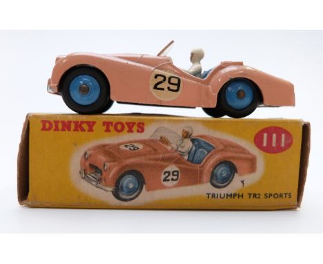 Dinky Toys diecast model Triumph TR2 Sports with salmon body, blue interior and white driver 111, in original box.&nbsp;