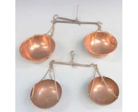 Two travelling beam scales with copper pans, one marked Avery, width of larger 26cm
