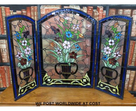A triptych leaded glass firescreen with urn of flowers design 