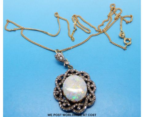 An 18ct gold and platinum pendant set with a large opal surrounded by old cut diamonds on an 18ct gold chain