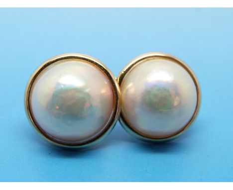 A pair of yellow metal earrings each set with a mingle Mabe pearl 