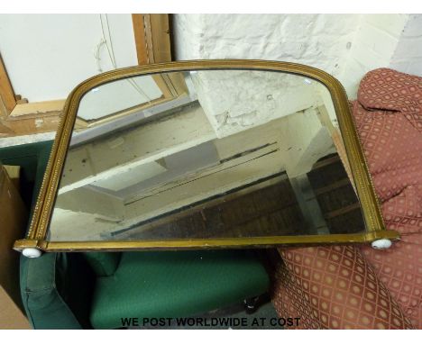 A gilt framed over-mantel mirror with arched top, raised on ceramic bun feet (110 x 84cm)