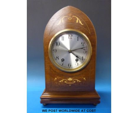 A late 19thC / early 20thC two-train mantel clock with inlaid mitre shaped case, silvered dial and striking on a gong
