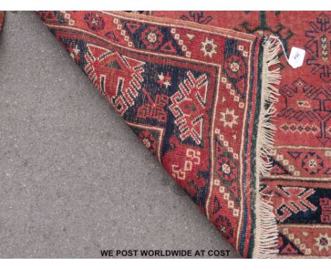 Three wool rugs, one geometric on pink ground (190cm x 118cm)  , one geometric on light brown ground (141 x 107cm), the other