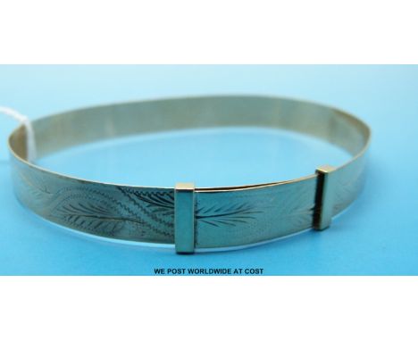A 9ct gold bangle with chased decoration