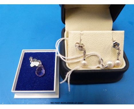 A 9ct white gold pendant set with a pearl and diamonds with matching earring together with a white metal pendant marked 10k s