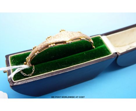 An Edwardian hallmarked 9ct gold bangle with chased floral decoration in original box for Walter Wells & Sons, Stroud 