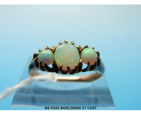 A gold ring set with an oval opal flanked by two round (size L) 