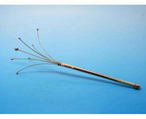 A yellow metal swizzle stick