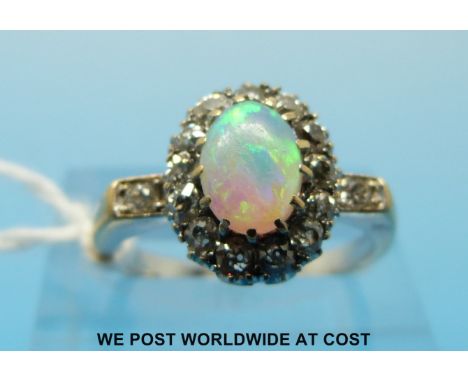 An 18ct gold ring set with an opal surrounded by diamonds (size N) 