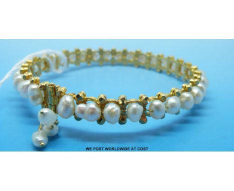 A yellow metal bangle set with 32 blister pearls, believed 22ct gold 