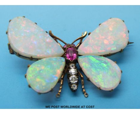 A Victorian gold brooch in the form of a butterfly, its wings made of opal with a ruby and diamond set body