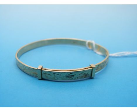 A 9ct gold christening bangle with chased decoration 