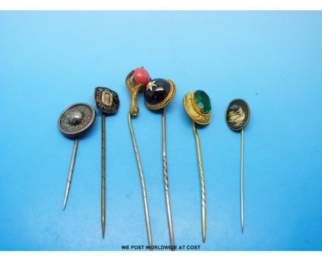 A group of yellow metal stick pins variously set with an oval green stone, a garnet and a pearl, a mourning stick pin with gl