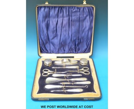 A cased and engine turned hallmarked silver 11 piece manicure / dressing table set, Birmingham 1924