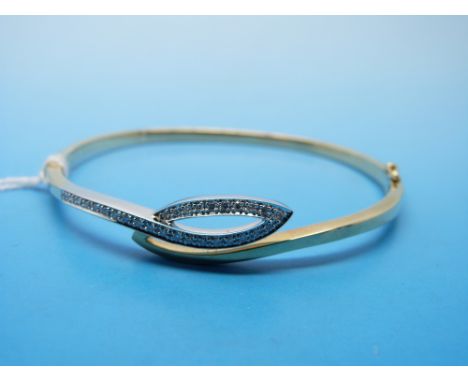 A 9ct gold bangle set with diamonds in a white gold setting 