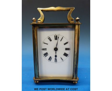 A brass timepiece carriage clock in corniche style case with finial decoration