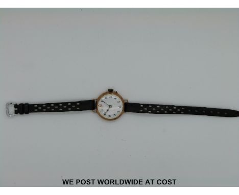 A 9ct gold cased ladies wristwatch with enamel face and Arabic numerals and a silver fob watch with chased decoration 