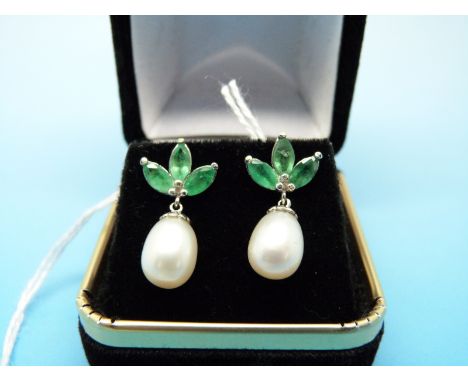 A pair of 14ct white gold earrings each set with three emeralds and a drop pearl