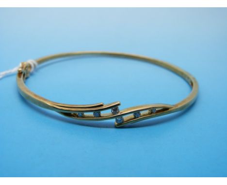 A 9ct gold bangle set with six diamonds 
