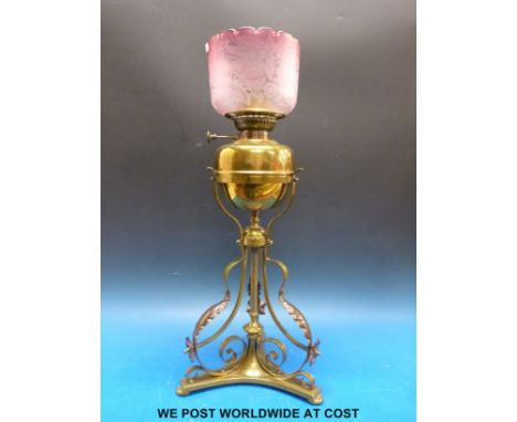 A 19thC ornate brass oil lamp in the manner of Benson with etched cranberry glass shade (height 62cm) 