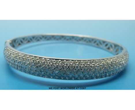 An 18ct white gold bangle, half set with five rows of round brilliant cut diamonds 