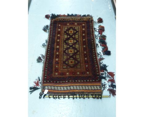 An Afghan rug with geometric design, ceramic beads and brass hanger 