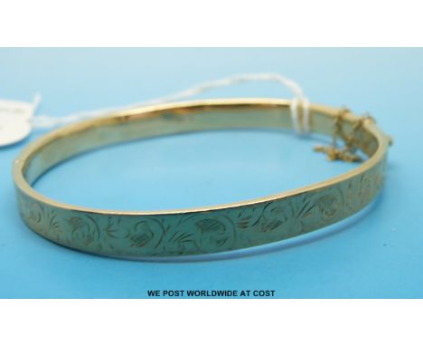 A 9ct gold bangle with chased decoration 