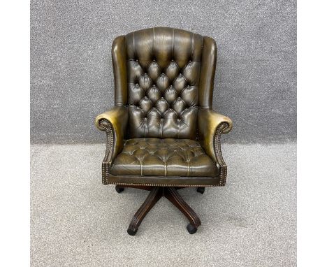 A 19th century style green faux leather button back and stud-work captain's swivel armchair with a tilt action on five reeded