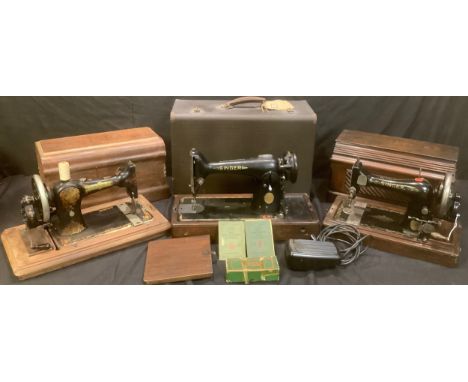 A Singer manual sewing machine, wooden carry case; another; a Singer electric sewing machine, cased with accessories (3) 