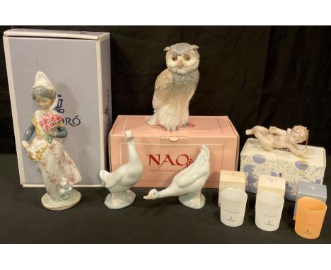 A Lladro porcelain figure, Valencian Girl with Flowers, 01304, boxed; another, Surprised Cherub, boxed; a Nao by Lladro model